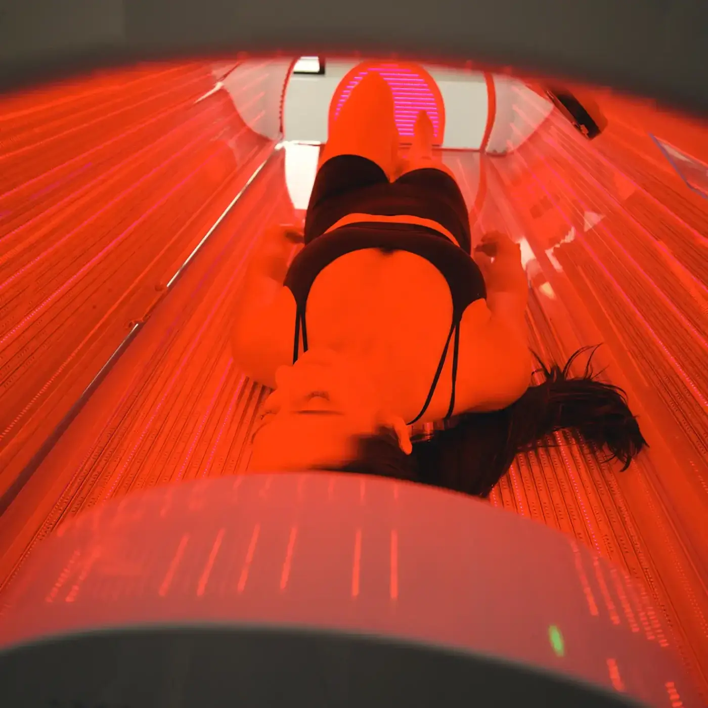 Patient receiving full-body red light therapy in a TheraLight photobiomodulation bed